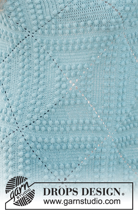 Rain Puddles / DROPS 229-6 - Manta crochetada com borbotos em DROPS Sky. É composta por quadrados.