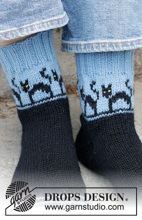 Spooky Evening Socks / DROPS 244-45 - Gebreide sokken in DROPS Karisma. Het werk wordt gebreid vanaf de teen in de hoogte, met een veelkleurig patroon met katten en sleehak. Maten 35-43. Thema: Halloween.