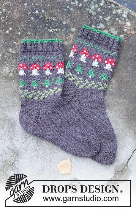 Mushroom Season Socks / DROPS 246-43 - Strikkede halvlange sokker til herre i DROPS Karisma. Arbeidet strikkes ovenfra og ned i glattstrikk med flerfarget mønster med sopp og grantre. Størrelse 35 – 46. Tema: Jul.