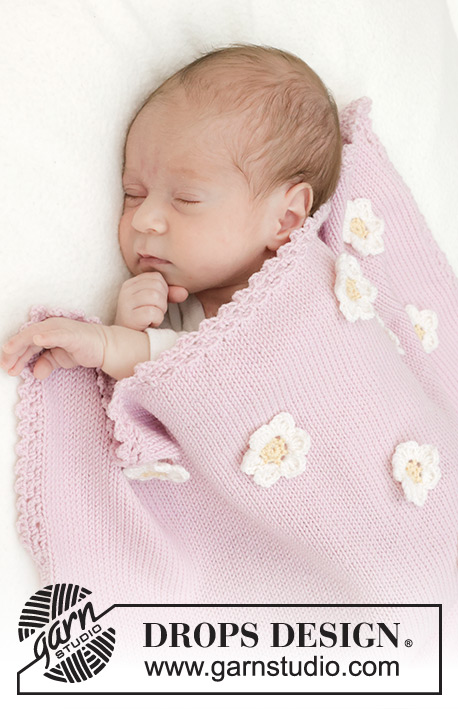 Little Daisy Blanket / DROPS Baby 46-1 - Gestrickte Decke für Babys in DROPS BabyMerino. Die Arbeit wird glatt rechts mit gehäkeltem Rand und gehäkelten Blumen gestrickt. Thema: Babydecke