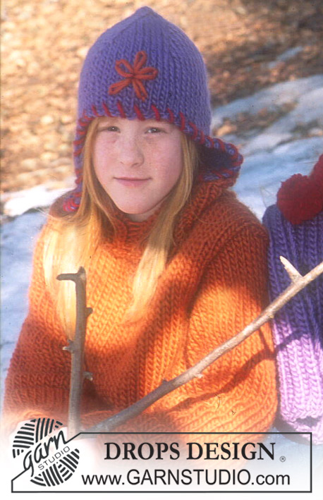DROPS Children 12-43 - Strikket sett med genser og lue til barn i DROPS Snow. Arbeidet strikkes og blomst og kant syes og broderes på. Størrelse 3 - 14 år.