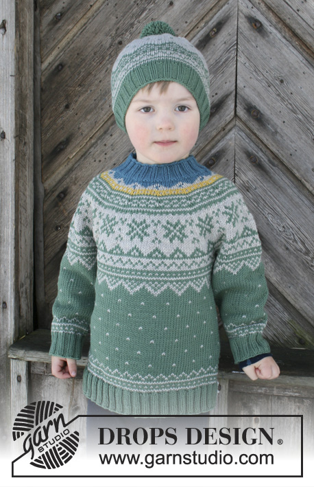 Seiland Jumper / DROPS Children 30-5 - L'ensemble se compose de: Pull au tricot pour enfant avec empiècement arrondi et jacquard norvégien, tricoté de haut en bas. Bonnet au tricot pour enfant, avec jacquard norvégien et pompon. Du 2 au 12 ans. L’ensemble se tricote en DROPS Merino Extra Fine.