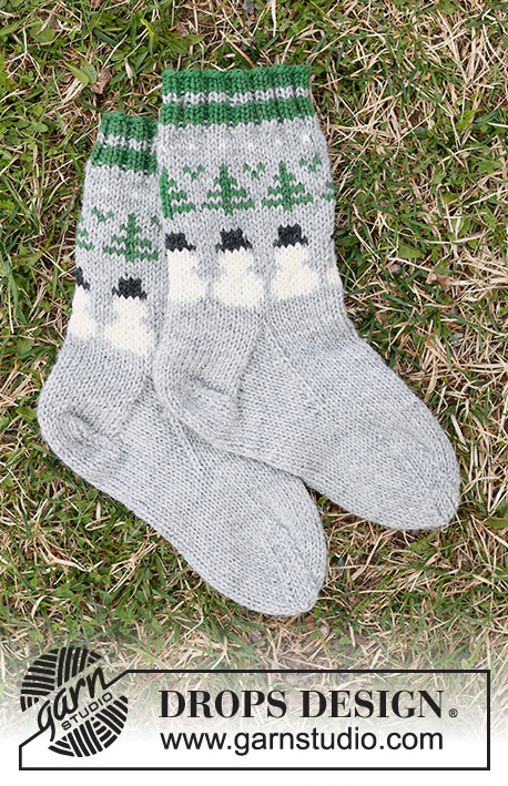 Snowman Time Socks / DROPS Children 44-21 - Calcetines de punto para niños en DROPS Karisma. La pieza está tejida de arriba hacia abajo con patrón de jacquard de muñeco de nieve y árbol de Navidad. Números 24 – 43. Tema: Navidad.