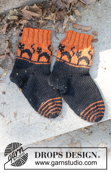 Spooky Sunset Socks / DROPS Children 47-29 - Strikkede sokker til barn i DROPS Karisma. Arbeidet strikkes fra tåen og opp i flerfarget mønster med katter og kilehæl. Størrelse 35-43. Tema: Halloween.