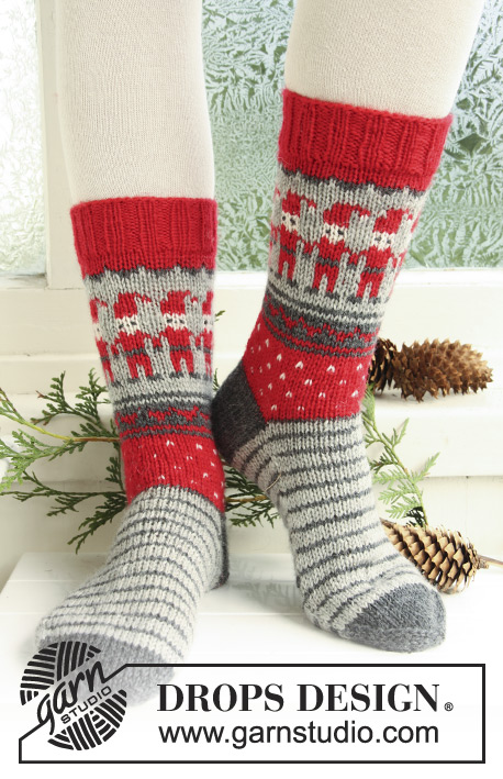 Dancing Elves / DROPS Extra 0-722 - Strikkede sokker til barn og voksen i DROPS Karisma. Arbeidet strikkes med mønster med julenisse, striper og hjerter. Størrelse 32 - 43. Tema: Jul