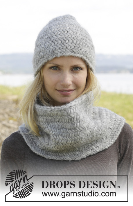 Emmie Gray / DROPS 158-34 - Knitted DROPS hat and neck warmer with herringbone pattern in Cloud or Snow.