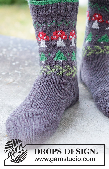 Mushroom Season Socks / DROPS 246-43 - Strikkede halvlange sokker til herre i DROPS Karisma. Arbeidet strikkes ovenfra og ned i glattstrikk med flerfarget mønster med sopp og grantre. Størrelse 35 – 46. Tema: Jul.