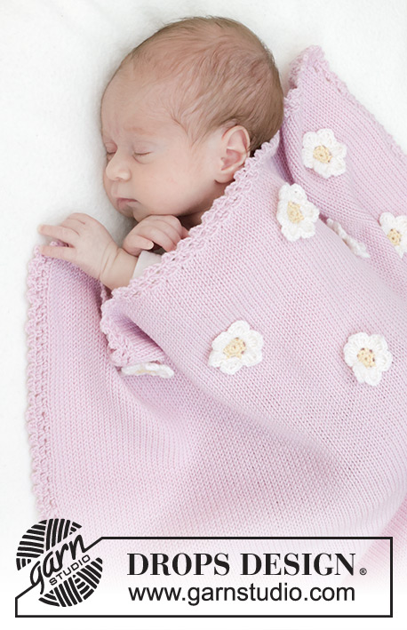 Little Daisy Blanket / DROPS Baby 46-1 - Gestrickte Decke für Babys in DROPS BabyMerino. Die Arbeit wird glatt rechts mit gehäkeltem Rand und gehäkelten Blumen gestrickt.