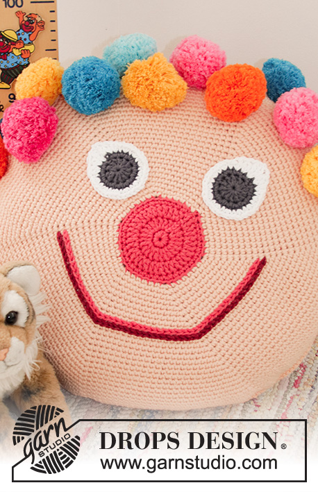 Bongo the Clown Pillow / DROPS Children 35-1 - Crocheted clown: round pillow casing with pompoms for children, crocheted in the round from center outwards. Piece is crocheted in DROPS Paris.