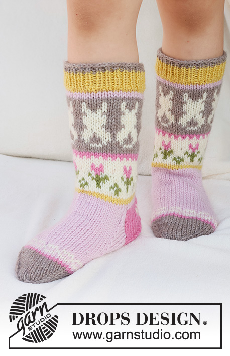 Dancing Bunny Socks / DROPS Children 41-35 - Knitted socks for children in DROPS Karisma. The piece is worked top down in stocking stitch, with multi-coloured pattern and heart, Easter chick, Easter bunny and flower. Sizes 24 - 43. Theme: Easter.
