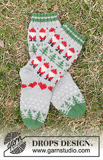 Christmas Time Socks / DROPS Children 44-20 - Gebreide sokken voor kinderen in DROPS Karisma. Het werk wordt van boven naar beneden gebreid met gekleurd patroon van kerstman, kerstboom en hartje. Maten 24 – 43. Thema: Kerst.