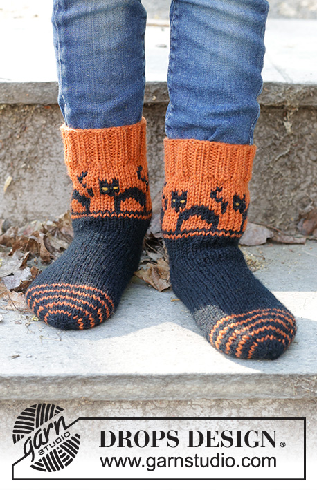 Spooky Sunset Socks / DROPS Children 47-29 - Strikkede sokker til børn i DROPS Karisma. Arbejdet strikkes fra tåen og op i flerfarvet mønster med katte og kilehæl. Størrelse 35-43. Tema: Halloween.